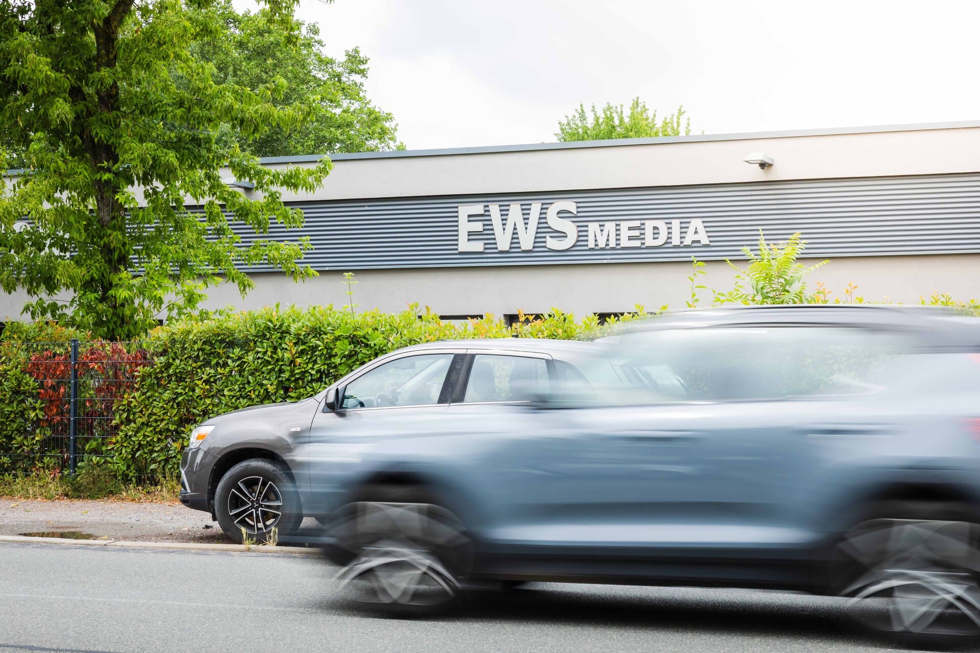 EWS Gebäude Aussenansicht mit fahrenden Autos davor